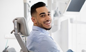 Man smiling while sitting in dentist's treatment chair
