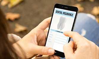 A patient reviewing their dental insurance policy on their phone