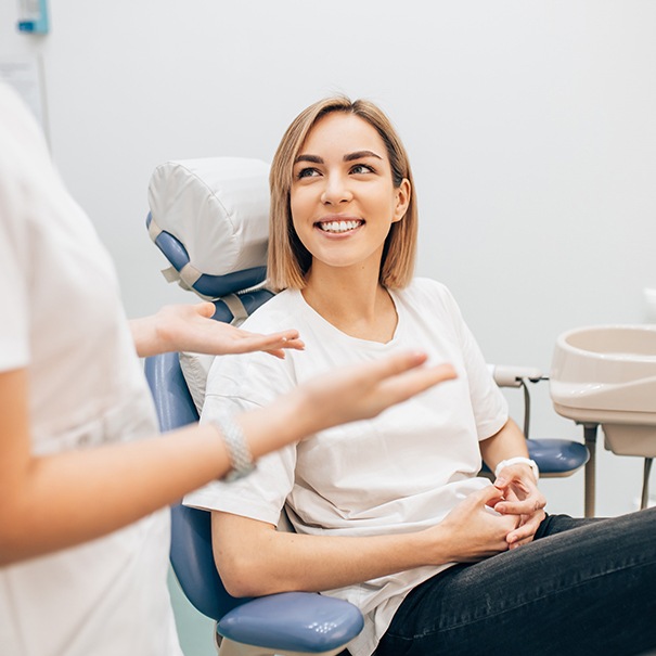 Woman in dental chair smiling at dentist