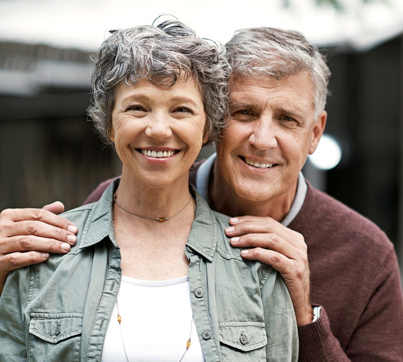 Older man and woman with dentures smiling