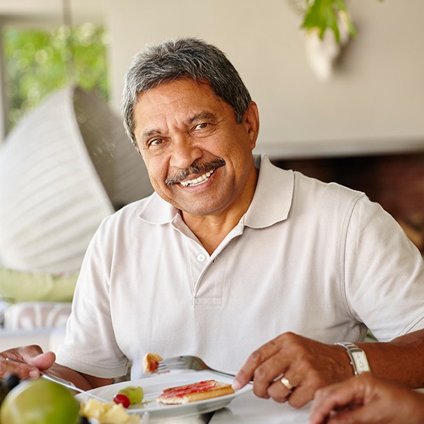 Man with dentures eating a meal