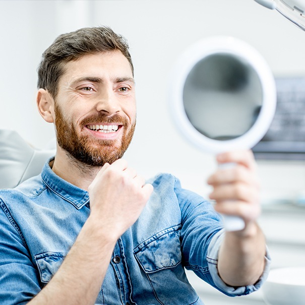 Man looking at smile after dental checkup