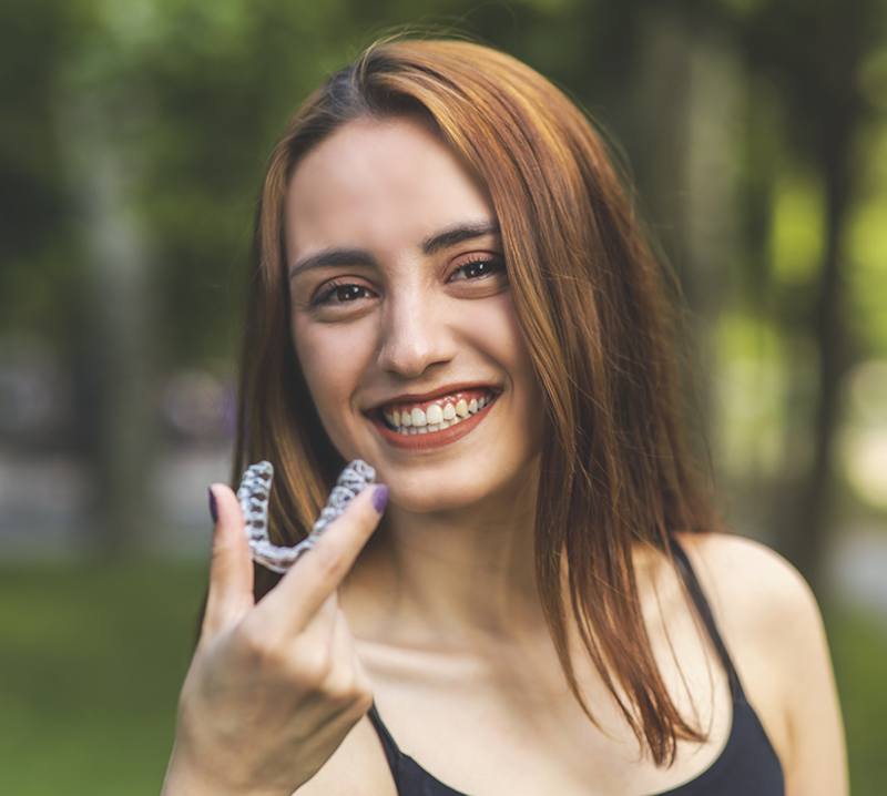 Woman placing an Invisalign tray