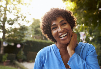 Woman sharing healthy smile after replacing missing teeth with dental implants