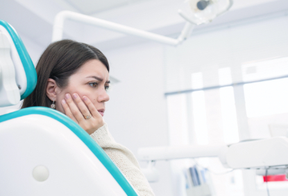 Woman in need of emergency dentistry holding jaw in pain