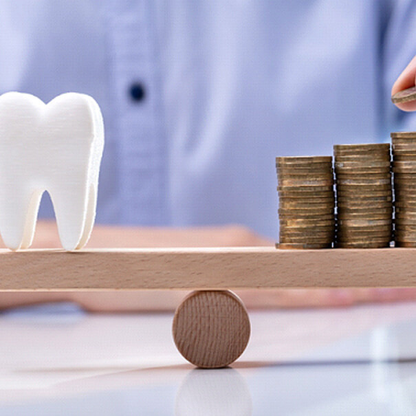 tooth balanced against a pile of coins