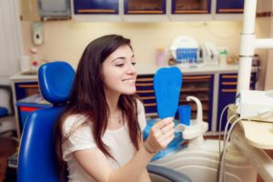 teenage girl looking at her smile in a mirror 