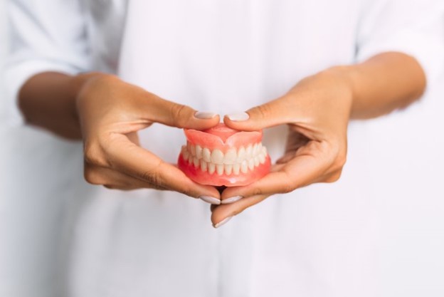 Person holding new dentures.